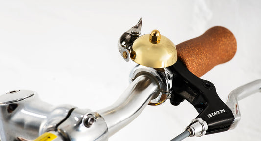 Swifty brass bell mounted on scooter handlebar